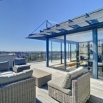 Terrasse spacieuse avec salon d’extérieur en rotin, vue panoramique sur la ville de Bruxelles