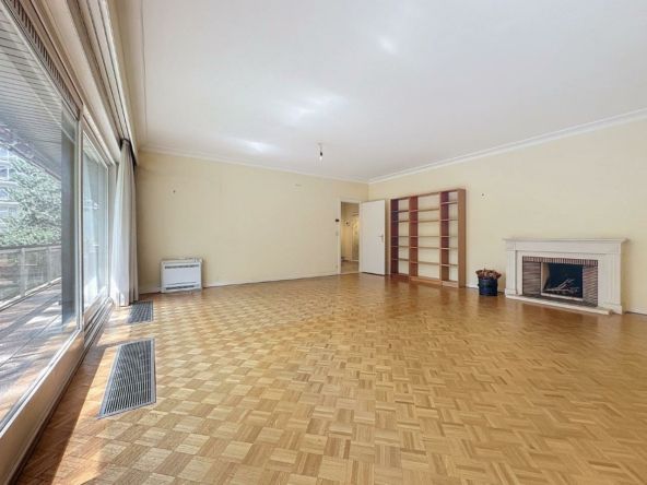 Lichte woonkamer met open haard, traditionele parketvloer en flexibele ruimtes om je inrichting aan te passen.