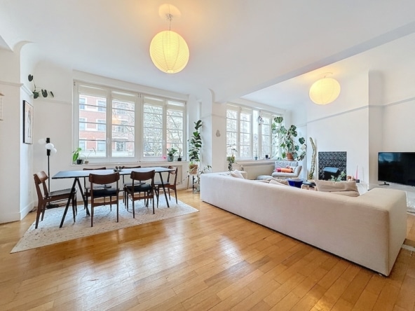 Een lichte, moderne woonkamer met elegante meubels, planten en natuurlijk licht om een warme sfeer te creëren.
