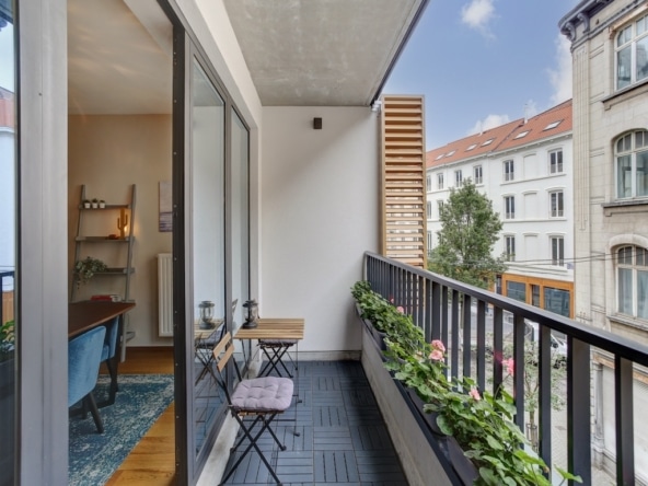 Modern balkon met planten, blauwe fauteuil, uitzicht op de stad, natuurlijk licht, zen en vriendelijke sfeer.