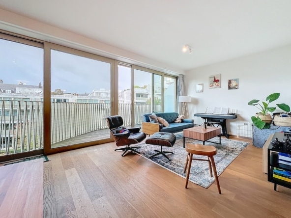 Lichte woonkamer met panoramisch uitzicht, blauwe bank, zwarte piano en elegante minimalistische inrichting.