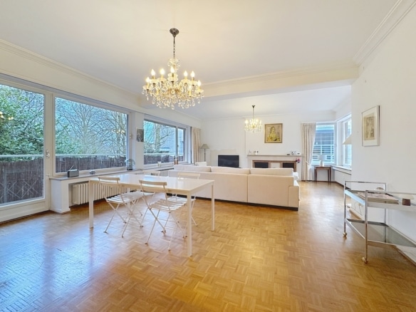 Salon lumineux moderne avec parquet, cheminée, mobilier minimaliste et décoration élégante.