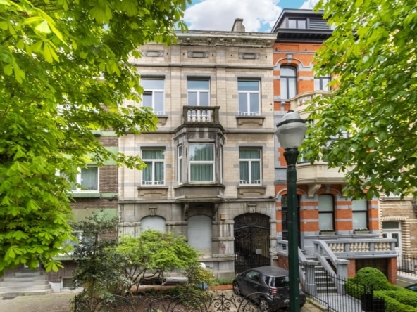 Historische stenen woning omgeven door groen, met sierlijke trap en moderne voorzieningen.