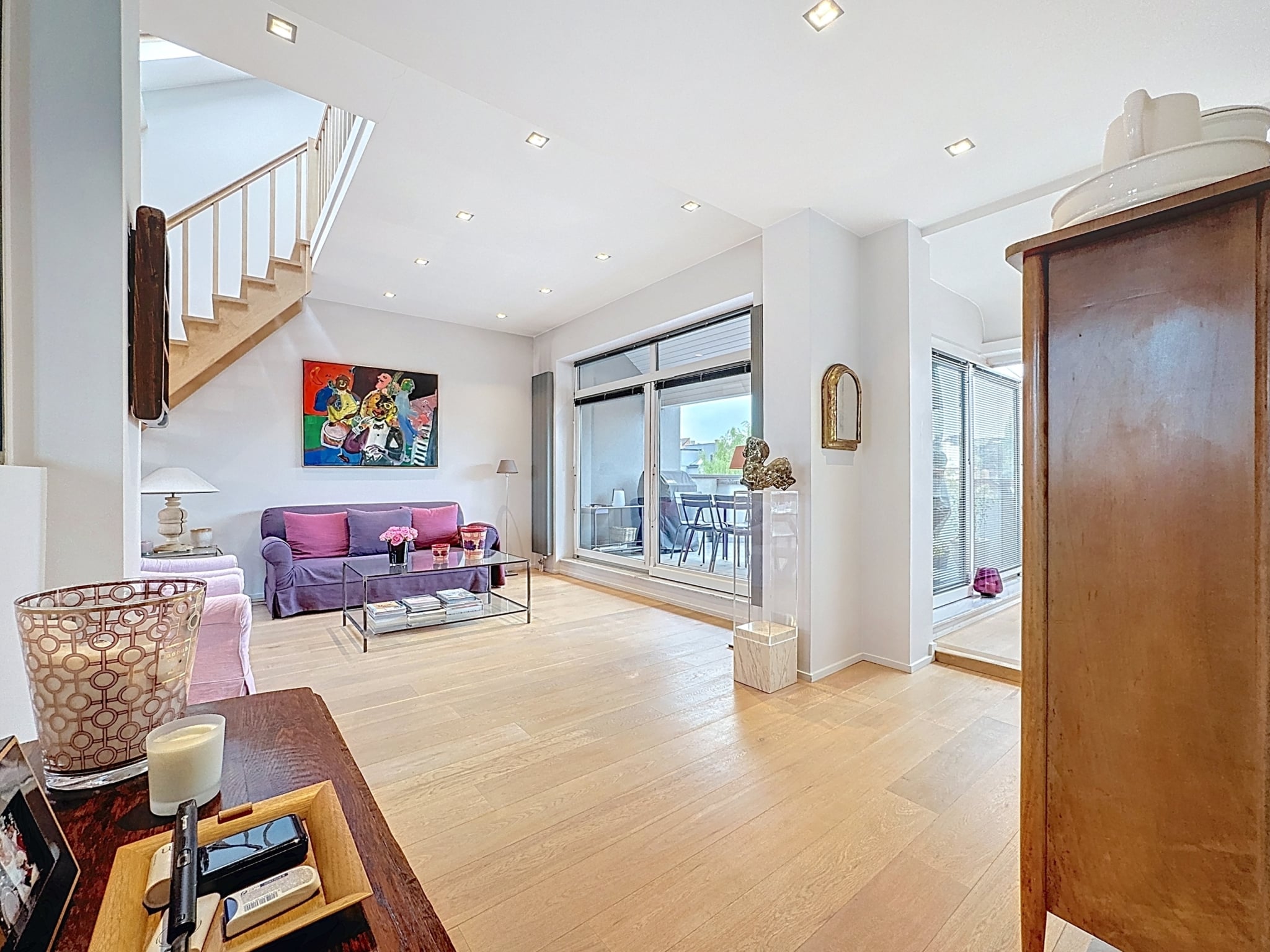 Modern interieur met kleurrijke stoelen en elegante trap Trap - Brugmannplein: 3 slaapkamers + bureau - terras en garage - Elsene