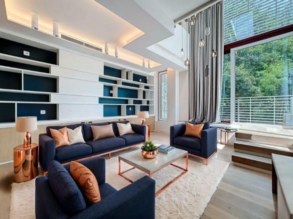 Salon moderne avec canapés bleu marine, lumière naturelle, touches de cuivre et ambiance chaleureuse.