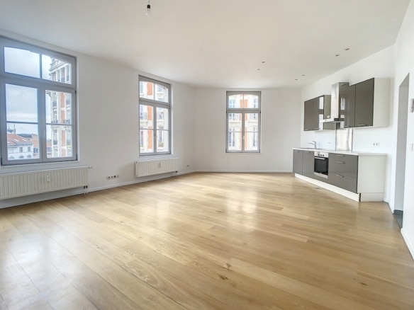 Salon moderne lumineux avec cuisine ouverte minimaliste, bois clair, grandes fenêtres et ambiance élégante.