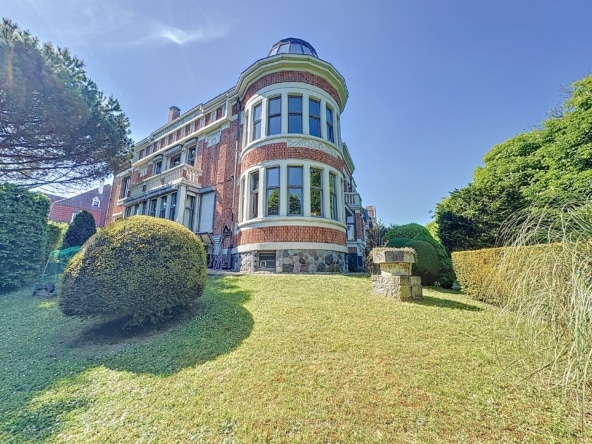 Luxe villa met koepel, verzorgde tuinen, weelderig groene gazons en majestueuze bomen.