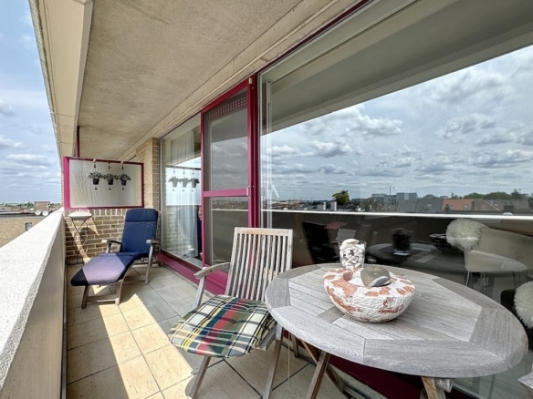 Balcon moderne avec mobilier confortable, vue urbaine et ambiance élégante.