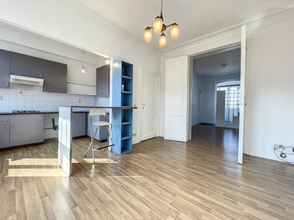 Salon lumineux avec cuisine moderne, mobilier minimaliste et espace ouvert accueillant.
