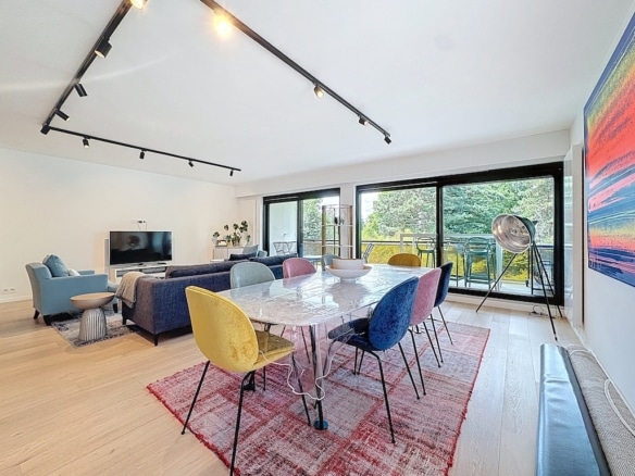 Salon et salle à manger modernes lumineux avec mobilier coloré et décoration artistique.