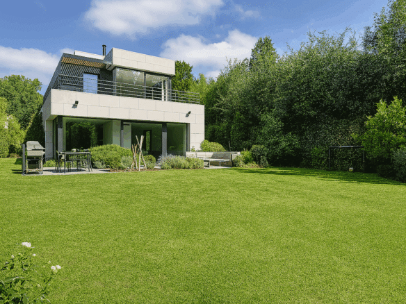 Maison contemporaine élégante avec grand jardin, espace lounge, et vues panoramiques en plein air.