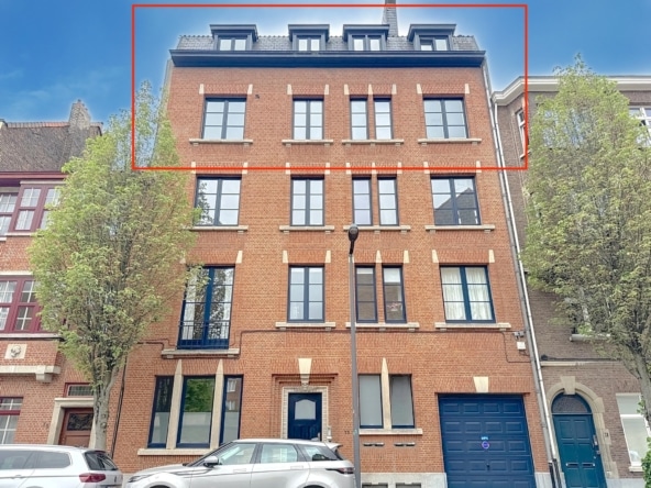 Stedelijk gebouw in rode baksteen met zwarte ramen, blauwe garage en groene bomen.