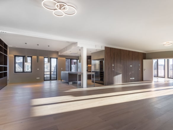 Intérieur contemporain lumineux avec cuisine élégante, sol en bois, grandes fenêtres et éclairage moderne.