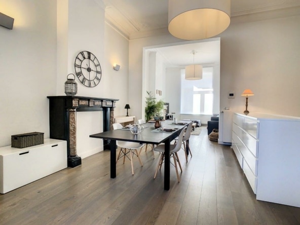 Lichte moderne woonkamer met open haard, strakke meubels en designverlichting, warme sfeer.