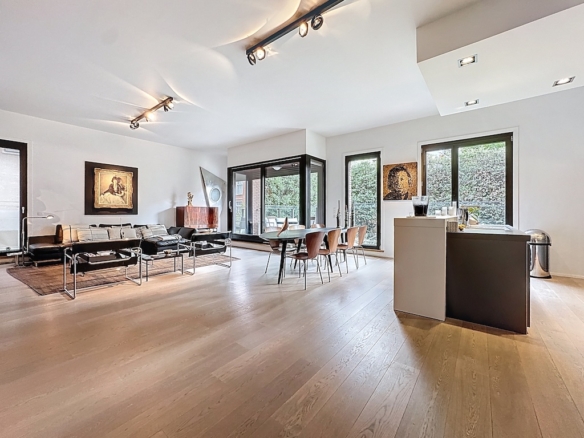 Intérieur moderne lumineux avec salon, cuisine épurée, mobilier élégant et vue panoramique.