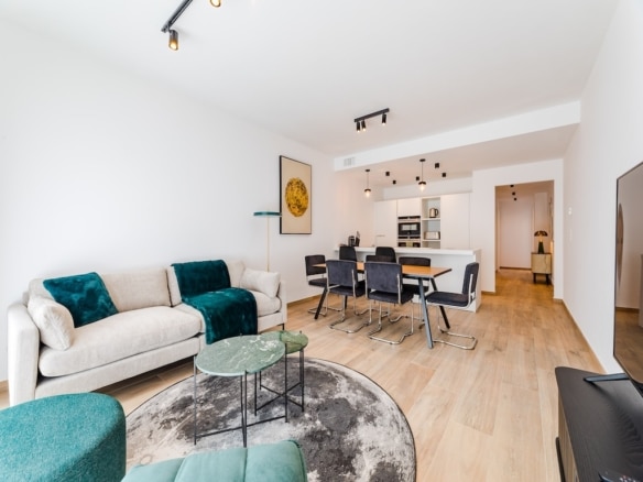 Salon contemporain lumineux avec canapé, espace repas élégant, décoration moderne et lumière naturelle.