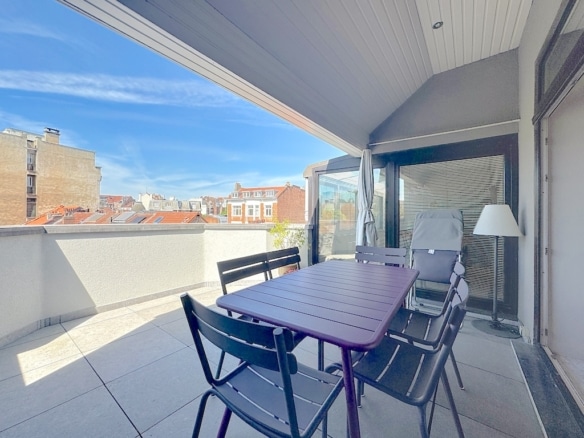 Terrasse urbaine accueillante avec mobilier moderne, vue sur les toits et ambiance détendue.