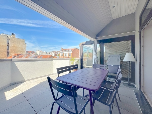 Terrasse urbaine accueillante avec mobilier moderne, vue sur les toits et ambiance détendue.