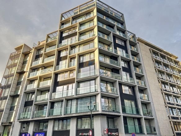 Immeuble moderne en verre et béton, avec balcons en urbanisme, ambiance lumineuse et dynamique.
