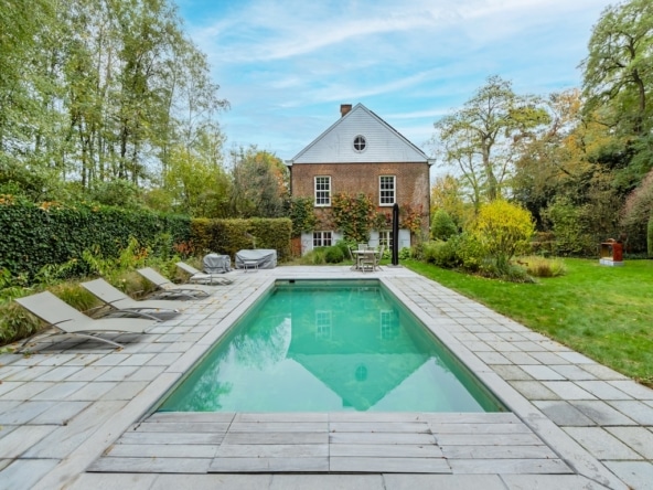 Jardin avec piscine maison en briques rouges et espace naturel paisible