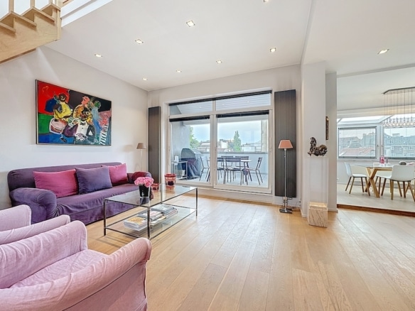 Salon lumineux, moderne, personnalisé avec art, canapé violet, grande fenestration et ambiance chaleureuse.