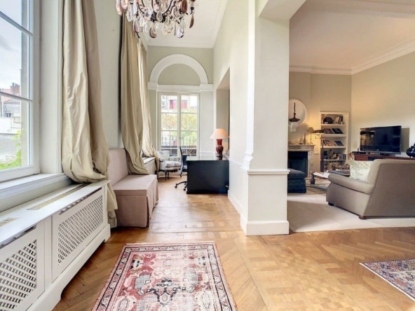 Salon moderne avec espace de travail, canapé cosy, tv, décoration élégante, lumière naturelle abondante.