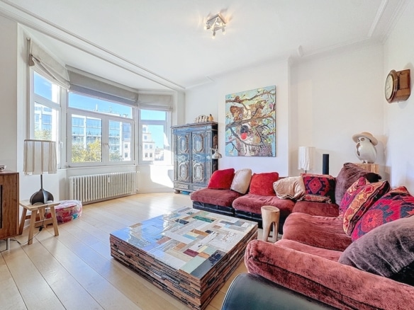 Salon moderne et chaleureux avec canapé en velours, mobilier recyclé et décoration artistique élégante.