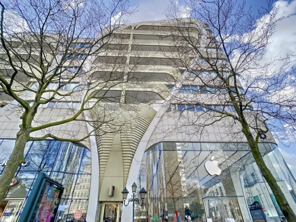Boutique Apple moderne avec façade en verre, design épuré, logo emblématique et environnement urbain.