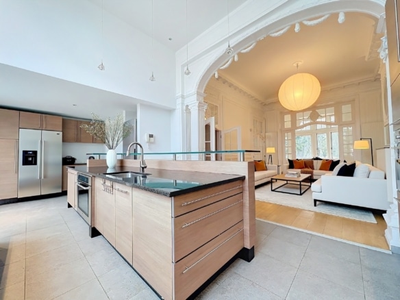 Lichte open keuken bij Gaulois met houten eiland en klassieke woonkamer