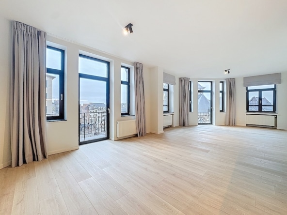 Salon lumineux avec grandes fenêtres vue urbaine parquet en bois clair style moderne et épuré