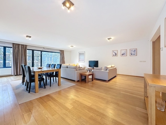 Salon contemporain lumineux avec mobilier minimaliste, bois, canapés neutres, grande luminosité naturelle.