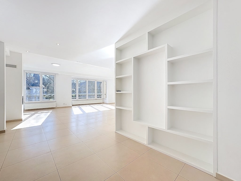 Licht interieur met grote ramen, moderne ruimte, neutrale vloer, ideaal om te personaliseren in Brussel.
