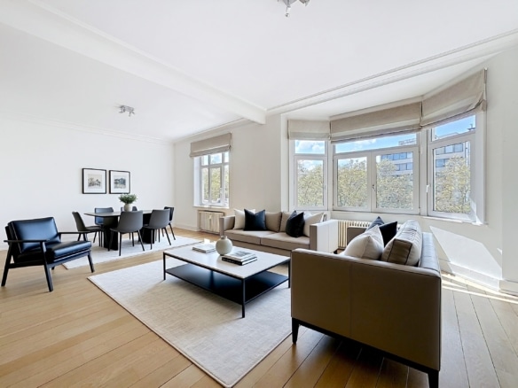 Moderne woon-eetkamer in Louise, lichte parketvloer, beige banken en uitzicht op het bos