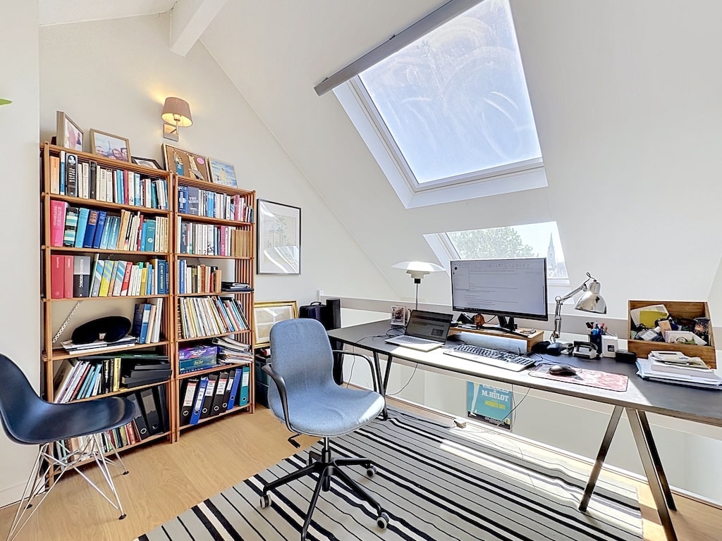 Bureau lumineux sous combles à Londres avec fenêtres de toit et bibliothèques