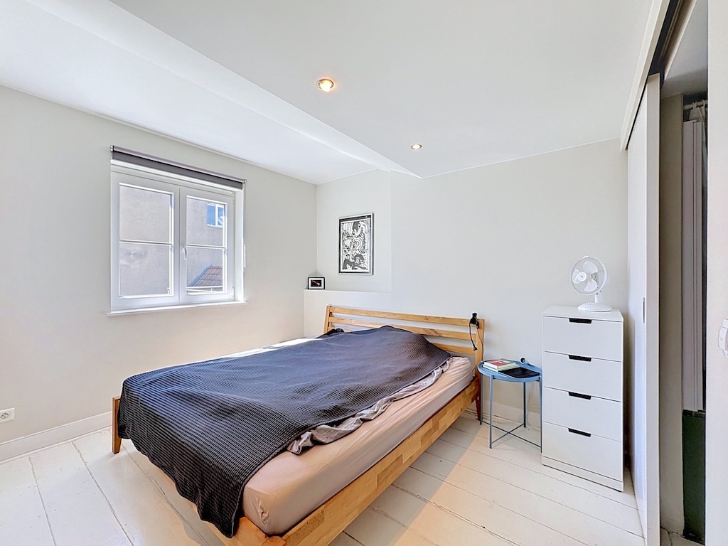 Chambre lumineuse à Londres avec lit en bois clair et placard coulissant