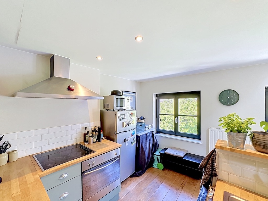 Cuisine moderne lumineuse à Londres avec plans de travail en bois et parquet