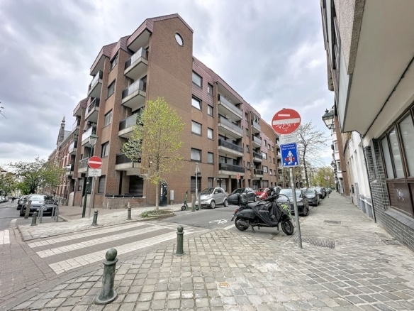 Brick residential building in Lausanne, paved street and grey balconies