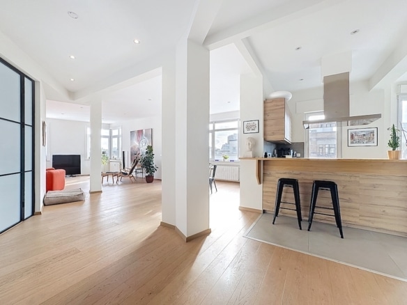 Lichte woonkamer met open keuken, houten eiland en rode bank