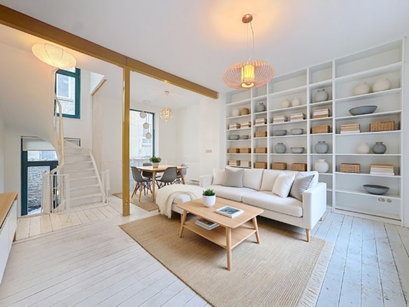 Lichte, minimalistische woonkamer met witte bank, ingebouwde planken en Scandinavische eethoek