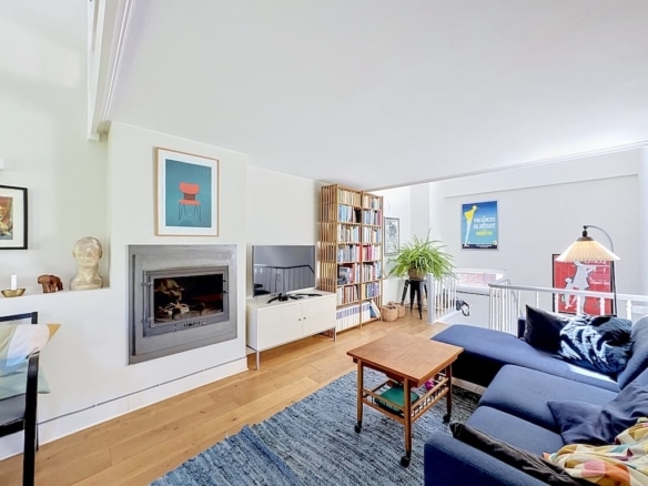 Lichte moderne woonkamer in Londen met blauwe bank, open haard en lichte parketvloer