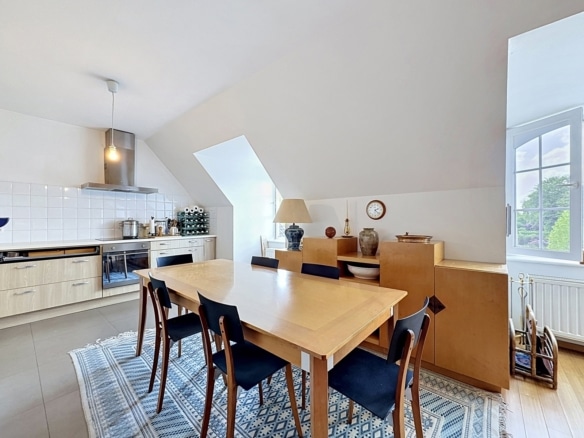 Cuisine équipée sous combles avec coin repas bois clair et vue arborée   appartement 2 chambres  rhode saint genèse