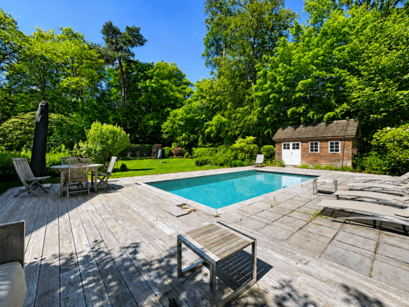 Piscine extérieure avec terrasse en bois transats et jardin arboré   maison 4 chambres  kraainem