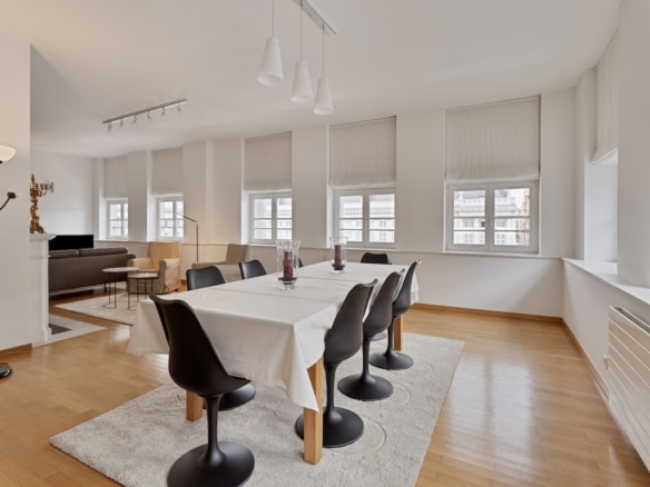 Bright dining room in Brussels with black table and chairs