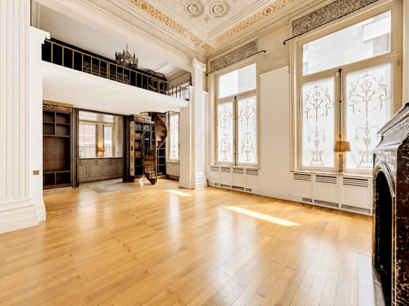 Salon bibliothèque lumineux avec mezzanine escalier en colimaçon et hauts plafonds moulurés   appartement 2 chambres  ixelles