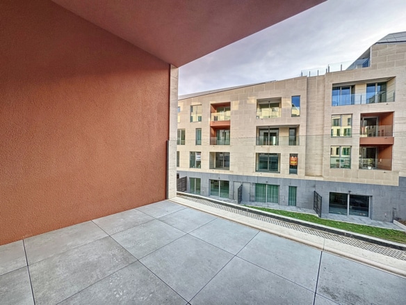 Terrasse couverte carrelée avec vue sur résidence neuve aux balcons vitrés   appartement 1 chambre  braine lalleud