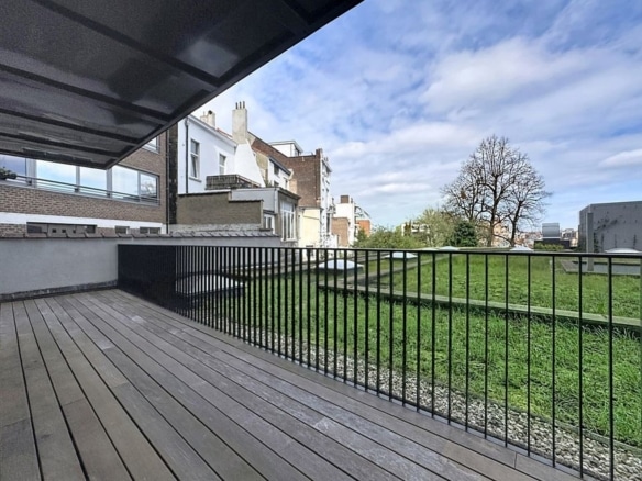 Terrasse moderne en bois avec garde corps noir sur jardin résidentiel verdoyant   appartement 1 chambre  bruxelles