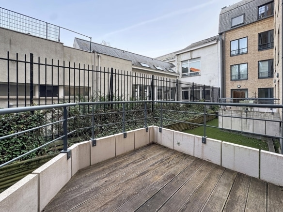 Terrasse privative en bois dun appartement avec garde corps et cour intérieure   appartement 1 chambre  bruxelles
