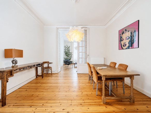 Salle à manger lumineuse avec parquet en bois table rustique et suspension design   appartement 1 chambre  uccle
