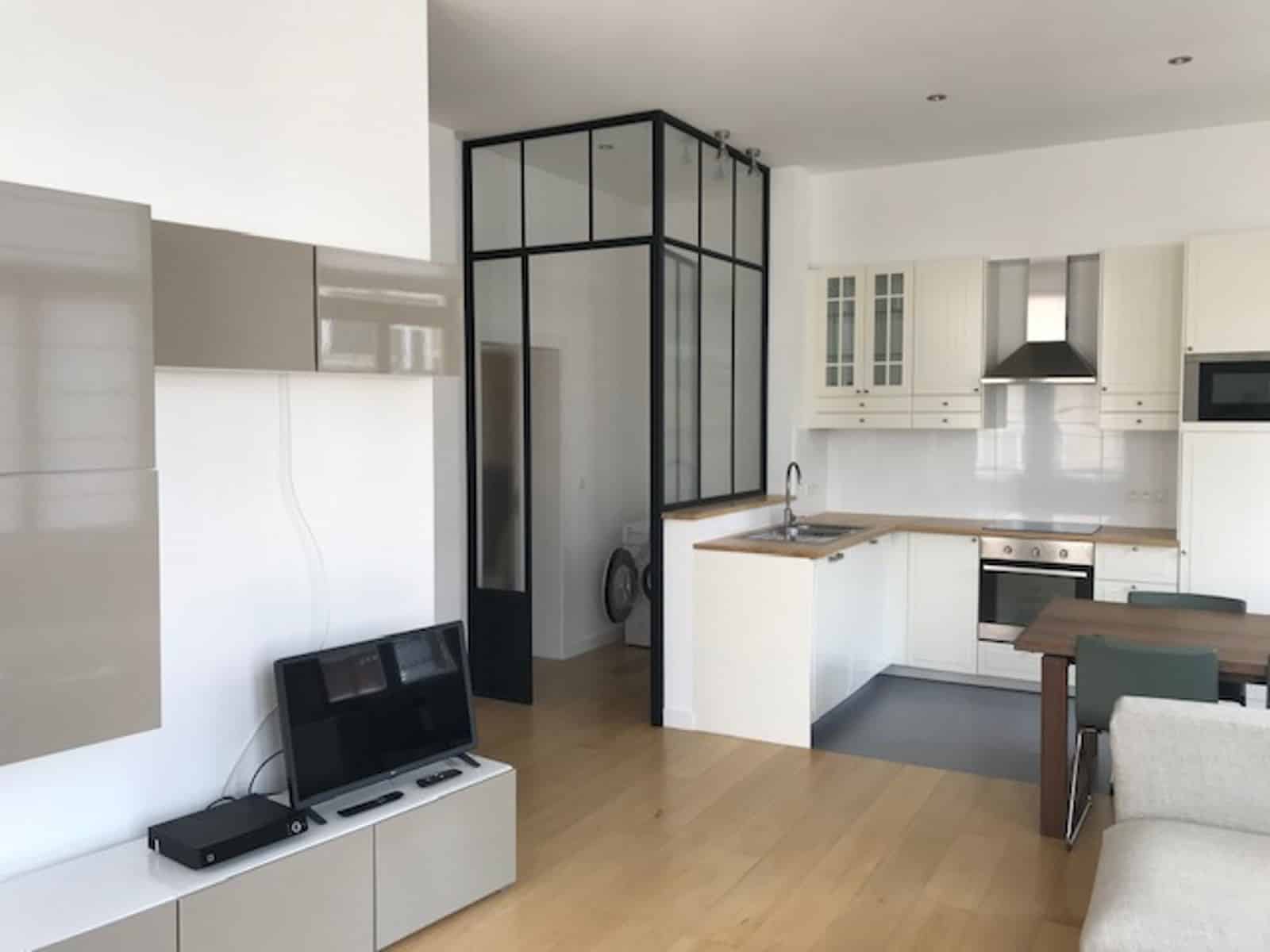 Modern apartment with an open-concept living room, a fully equipped kitchen, and a glass partition   1-bedroom apartment in Etterbeek