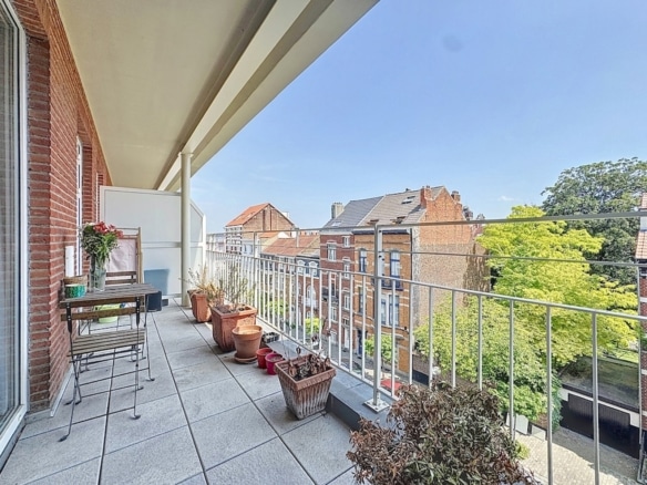 Terrasse couverte dappartement avec coin repas plantes et vue urbaine   appartement 2 chambres  uccle